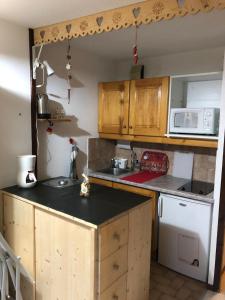 a small kitchen with a sink and a microwave at Résidence "Rado" in Samoëns