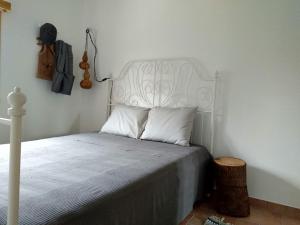 1 dormitorio con cama blanca y cabecero blanco en Villa Rominha Alvaiázere - Casa do Rancho, en Alvaiázere