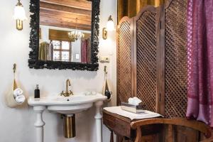 a bathroom with a sink and a mirror and a chair at Orlowska Townhouse Apartments in Kraków +58 photos