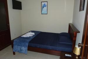 - une chambre avec un lit avec des draps bleus et une table dans l'établissement Hotel La Gran Sultana, à Granada