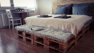 a bed with a bench made out of wooden pallets at Apartmán Lucie in Pardubice