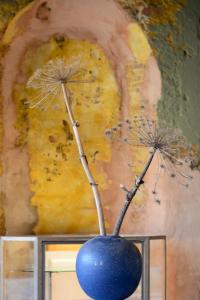 a blue vase with two dandelions in it at De Theetap in Zierikzee