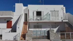 a white house with a staircase and a balcony at Un mare da sogno in Sannicola