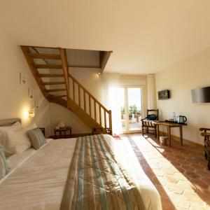 a bedroom with a large bed and a staircase at B&B Le Clos du Phare - En campagne in Saint-Samson-de-la-Roque