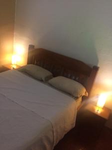 um quarto com uma cama branca e 2 candeeiros em Casa Colonial Térrea no Saco da Capela em Ilhabela em Ilhabela
