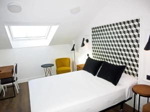 1 dormitorio blanco con 1 cama blanca y sillas en Hotel Colón Plaza, en Valladolid