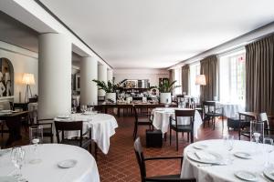 a restaurant with tables and chairs with white tablecloths at Hôtel Arcé - Piscine , Padel, Cheminée in Saint-Étienne-de-Baïgorry