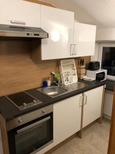 a kitchen with white cabinets and a sink at Appartements Dobler - s'Darhuam in Sankt Leonhard im Pitztal