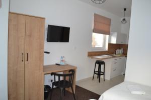 ein Schlafzimmer mit einem Schreibtisch und einem Bett sowie eine Küche in der Unterkunft Kalinowy Sen II in Warschau