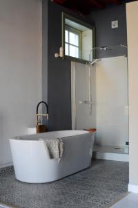 een badkamer met een bad en een raam bij De Theetap in Zierikzee