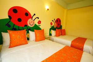 a bedroom with two beds with ladybugs painted on the walls at Kenting Avignon in Hengchun South Gate