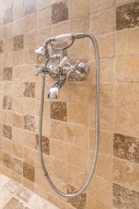 a shower with a hose attached to a wall at BonTon Apartments Sibiu in Sibiu