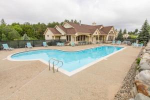 a house with a swimming pool in front of a house at Owl's Nest Resort in Thornton