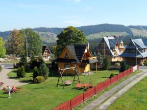 ムジャシフレにあるCottage in Tatra - Jacuzzi & Poolの芝生遊び場のある家屋群