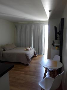 1 dormitorio con cama, mesa y ventana en Excelente Monoambiente Monito 15 en La Plata