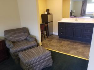 sala de estar con silla y lavamanos en Perry-O Inn & Suites en Star Junction