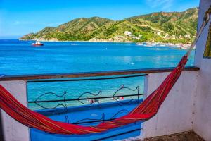 a hammock on a window with a view of the ocean at Hospedaje El Shadday in Taganga