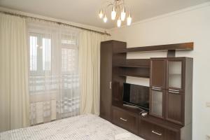 キーウにあるKyiv apartment on Chornovola 27のベッドルーム(テレビ付)、大きな窓が備わります。