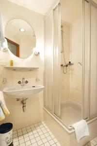 a white bathroom with a sink and a shower at Hotel Deutsches Haus in Kurort Gohrisch
