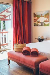 a bedroom with a bed with red pillows on a bench at Hôtel Arcé - Piscine , Padel, Cheminée in Saint-Étienne-de-Baïgorry +58 photos
