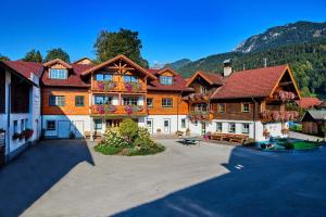 un grand bâtiment avec une cour en face d'une montagne dans l'établissement Linharterhof, à Haus im Ennstal