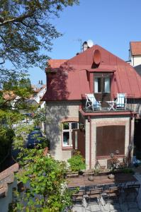 ein Haus mit einem roten Dach und einer Terrasse in der Unterkunft Villa Trumpetaren in Visby
