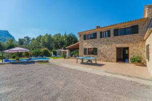a stone building with a picnic table in front of it at Villa El Olivo in Pollença