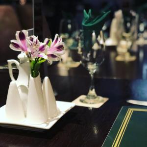 una mesa con un plato con una flor en un jarrón en The Racehorses Hotel en Kettlewell