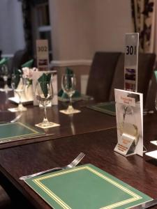 a wooden table with plates and wine glasses on it at The Racehorses Hotel in Kettlewell