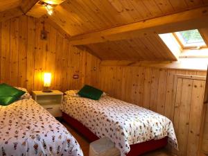 sypialnia z 2 łóżkami w drewnianym domku w obiekcie Casa Margherita w mieście Tarvisio