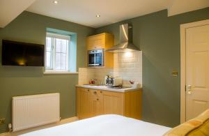 a small kitchen with green walls and a sink at Winckley Stays in Preston