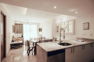 a kitchen with a sink and a dining room at Antera Hotel & Residences in Playa del Carmen