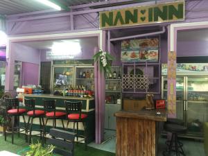 um restaurante com um bar com bancos em frente em Nan Inn Bungalow em Praia de Karon