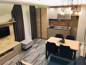 een keuken en een woonkamer met een tafel en stoelen bij Milmari Resort Premier 46 in Kopaonik