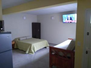 a bedroom with two beds and a tv on the wall at Apartamentos Croacia del Mar in Santa Clara del Mar