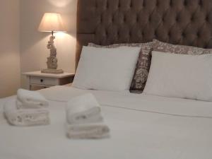 een bed met twee handdoeken en een lamp bij Goldfish Seaside Luxury Houses in Kómi