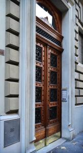 une porte en bois avec des panneaux de verre sur un bâtiment dans l'établissement Punto8, à Trieste