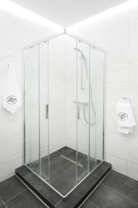 a glass shower in a bathroom with a toilet at AKURATNY Apartment in Poznań