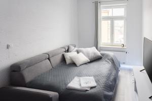 un sofá gris en una habitación con ventana en AKURATNY Apartment en Poznan