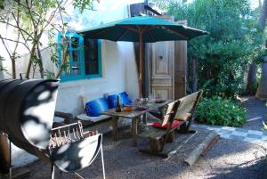 a patio with a table and an umbrella and chairs at La Escondida in Punta del Este