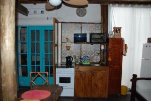 a small kitchen with a stove and a microwave at La Escondida in Punta del Este