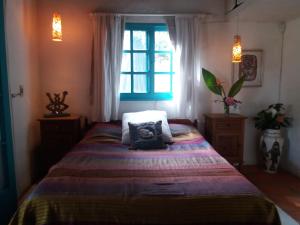 1 dormitorio con 1 cama grande y ventana en La Escondida, en Punta del Este