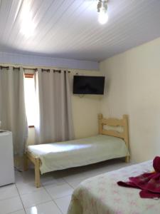 מיטה או מיטות בחדר ב-Suites do Reino Penedo RJ