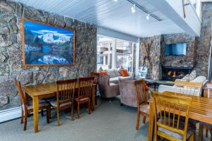 a living room with a table and a fireplace at Pokolodi Lodge in Snowmass Village