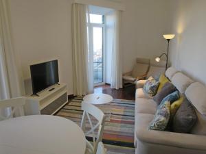 a living room with a couch and a tv at Market Downtown T3 in Funchal