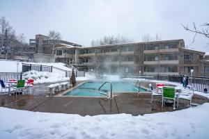 a swimming pool covered in snow in front of a building at Pokolodi Lodge in Snowmass Village