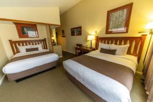 a hotel room with two beds and two lamps at Pokolodi Lodge in Snowmass Village