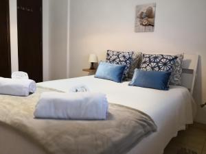 a bedroom with a large bed with blue pillows at Graça Lovers 2 in Lisbon