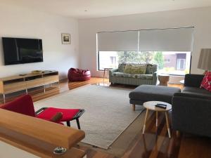 a living room with a couch and a tv at Pacific Paradise in Torquay