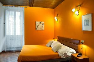 - une chambre orange avec un lit et une fenêtre dans l'établissement GREGORIANA HOUSE - Appartamento con Vista su Roma, à Rome